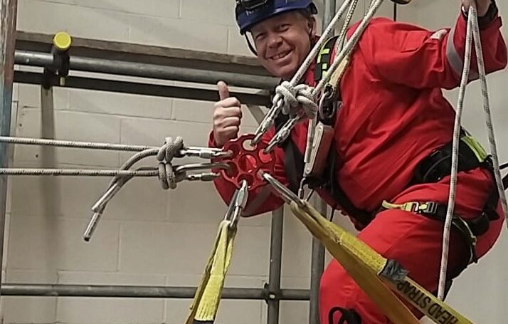 Man in red overalls doing a thumbs up for training development manager role