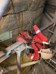 rope access professional from SA Safety. Man dressed in red overalls and safety harness working in a power station